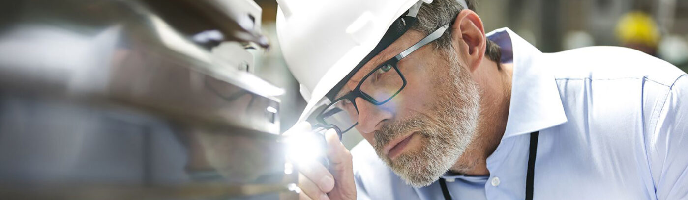 Man inspecting part with flashlight