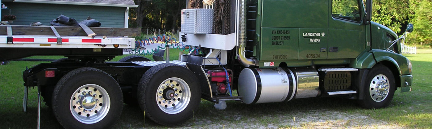 A green semi truck with a flatbed trailer featuring a link 6x2