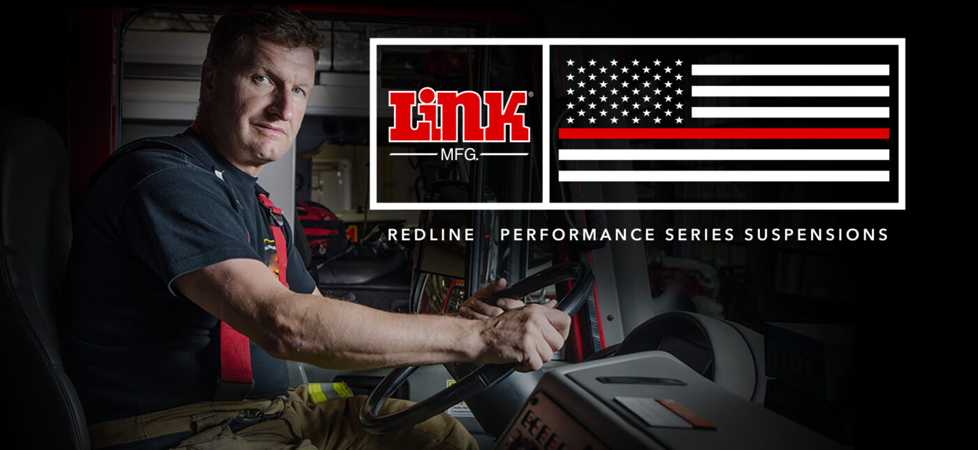 A firefighter sitting at the steering wheel of a firetruck with Link's Redline logo overlaid next to him