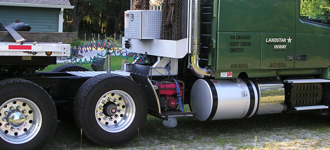 A green semi truck with a flatbed trailer featuring a link 6x2
