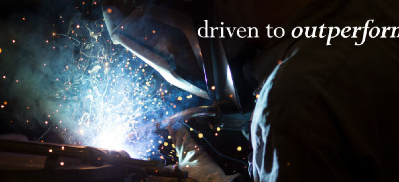 A welder welding with sparks flying, "driven to outperform" overlaid