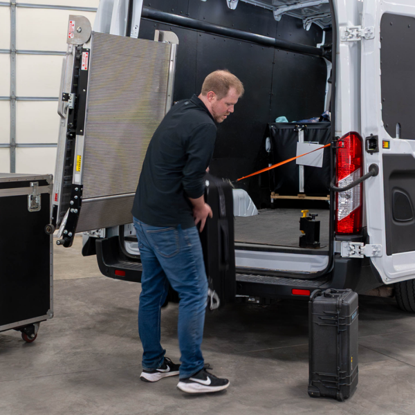 A man lifting a case of gear into a cargo van, with the Link LSR90 swivel ramp swiveled outwards to give him complete cargo access