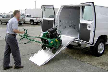 A man using the Link portable ramp to unload equipment from the back of a cargo van