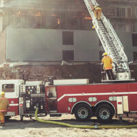Fire fighters on and near a ladder fire truck with the ladder extended