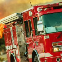 A fire truck in front of a forest fire