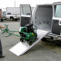 A man using the Link portable ramp to unload equipment from the back of a cargo van