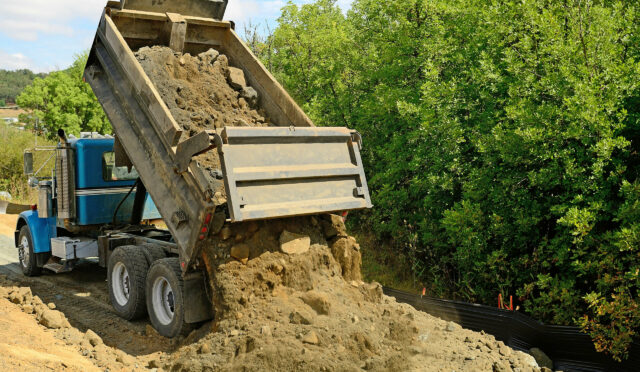 A dump truck dumping dirt
