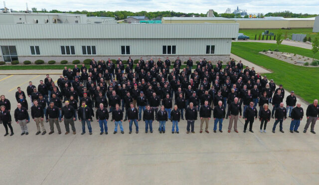 An Aerial photo of the Link employees outside of the Sioux Center, IA Link Mfg. Administrative Office in 2 Millionth Cabmate clothing