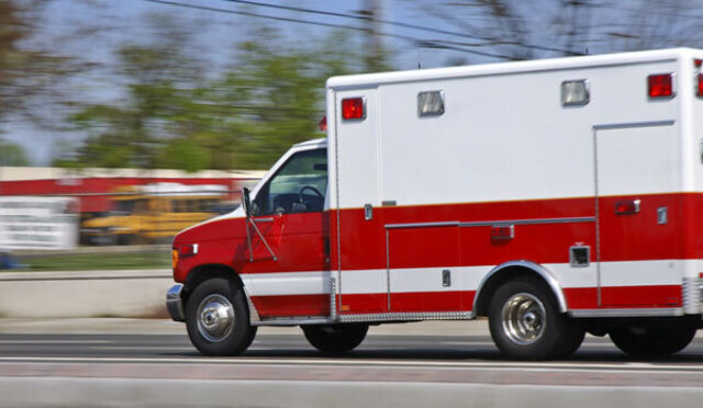 Ambulance moving at high speeds down a town road