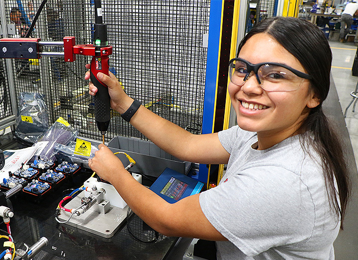 Woman assembling a SmartValve with a drill smiling at the camera
