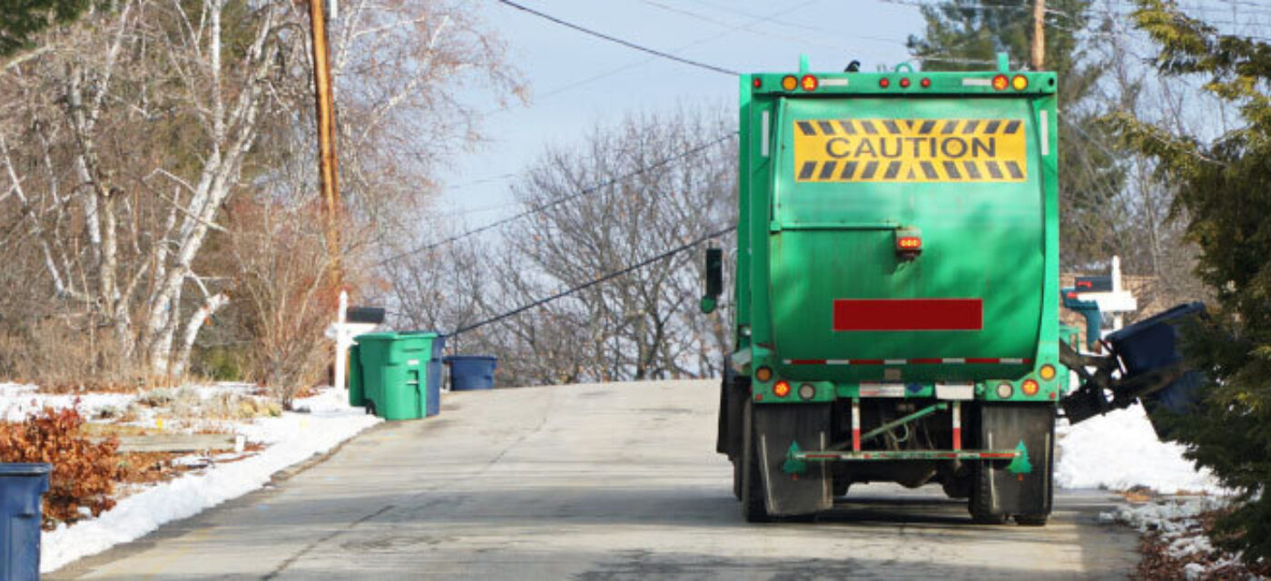 Trash collection truck collecting garbage in residential street