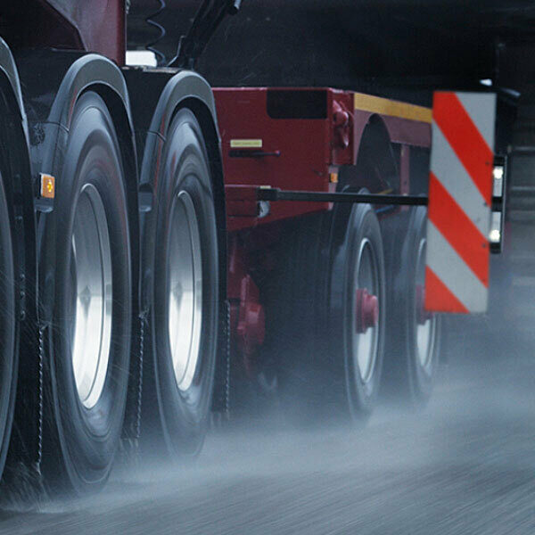 Tires on a semi truck and trailer on a wet road