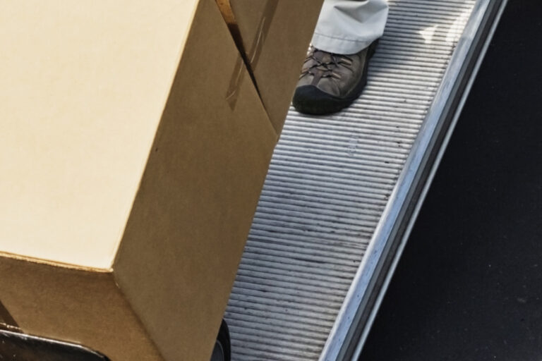 Person dollying several cardboard boxes up a ramp