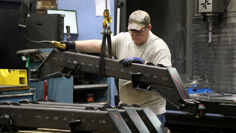 Man using lift system to move axle component