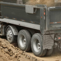 A dump truck with one visible steerable lift axle