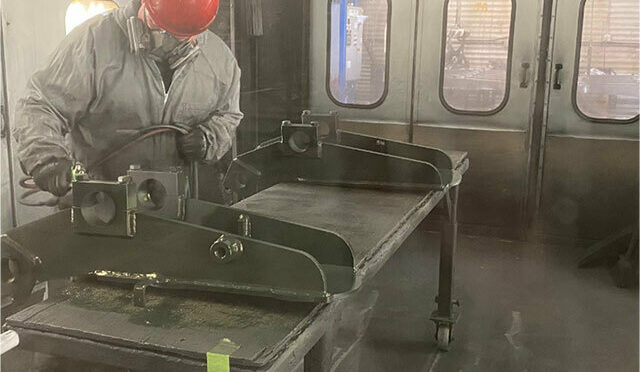A man painting parts in a paint booth