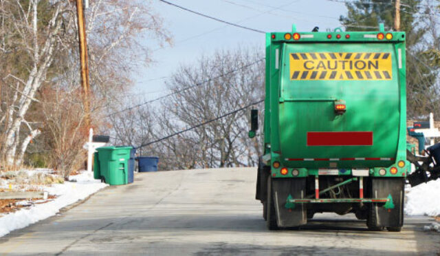 Trash collection truck collecting garbage in residential street